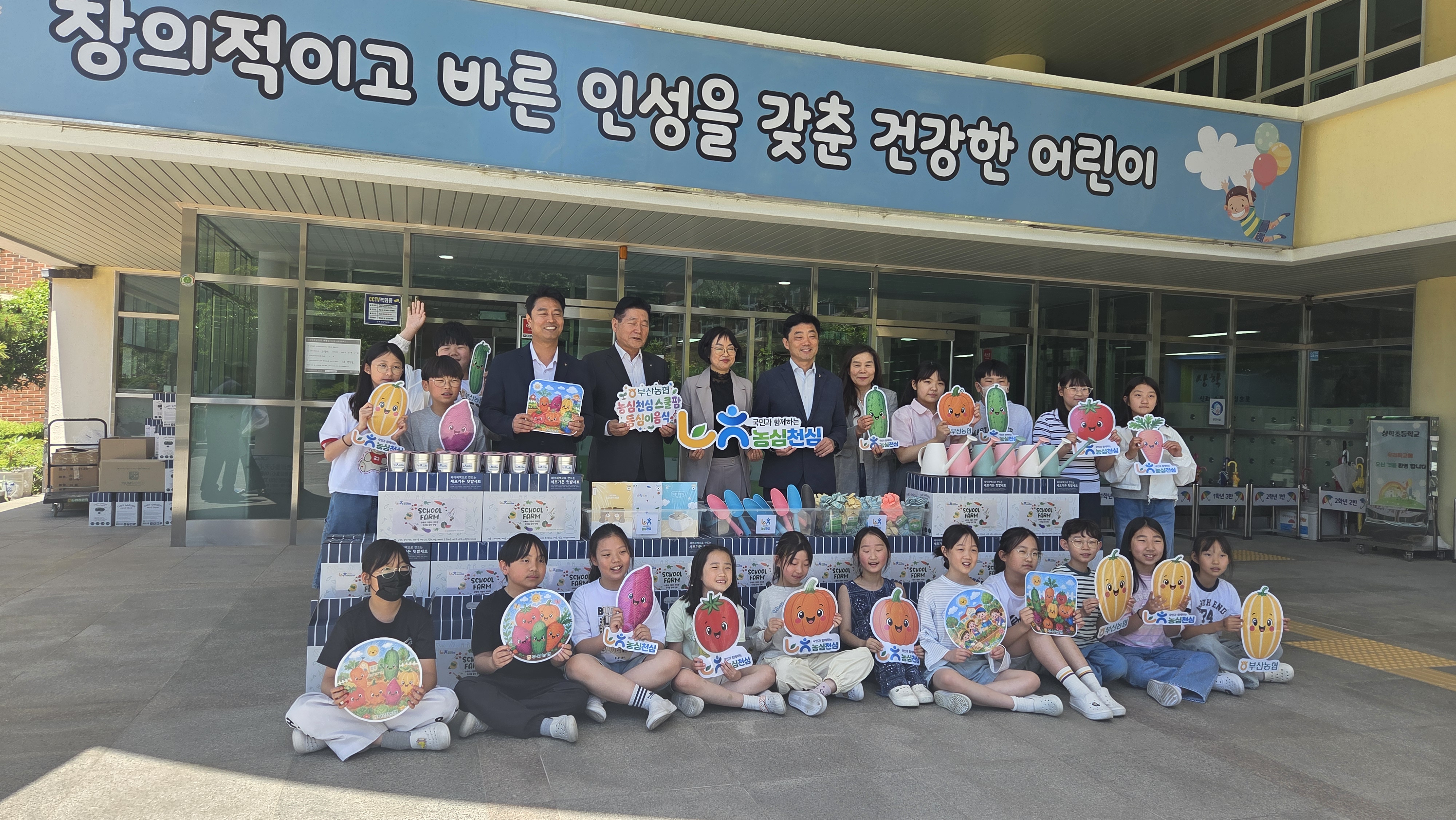 텃밭 세트(종이텃밭, 캔텃밭, 모종삽, 식물관찰일지, 물조리개)와 기념 사진